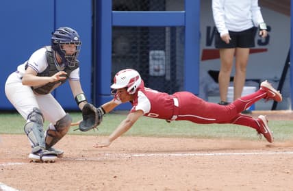 Jun 6, 2021; Oklahoma City, Oklahoma, USA;  Oklahoma's Rylie Boone (0) slides in at home past James Madison catcher Lauren Bernett (22) to score a run in the sixth inning during a Women s College World Series semi finals game at USA Softball Hall of Fame Stadium. Oklahoma won 6-3. Mandatory Credit: Alonzo Adams-USA TODAY Sports