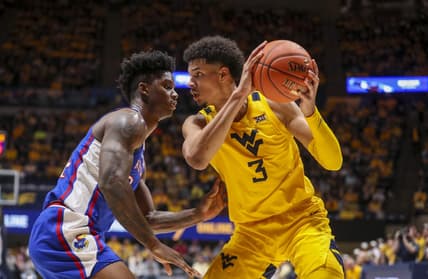 Jan 7, 2023; Morgantown, West Virginia, USA; West Virginia Mountaineers forward Tre Mitchell (3) pauses with the ball while defended by Kansas Jayhawks forward K.J. Adams Jr. (24) during the second half at WVU Coliseum. Mandatory Credit: Ben Queen-USA TODAY Sports