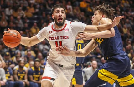 Feb 18, 2023; Morgantown, West Virginia, USA; Texas Tech Red Raiders forward Fardaws Aimaq (11) drives against West Virginia Mountaineers forward James Okonkwo (32) during the first half at WVU Coliseum. Mandatory Credit: Ben Queen-USA TODAY Sports