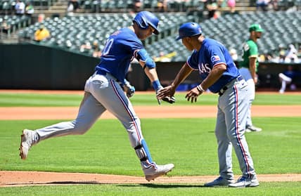 May 13, 2023; Oakland, California, USA; Texas Rangers infielder Nathaniel Lowe (30) celebrates with third base coach Tony Beasley (27) after hitting a home run during the fourth inning against the Oakland Athletics at Oakland-Alameda County Coliseum. Mandatory Credit: Robert Edwards-USA TODAY Sports