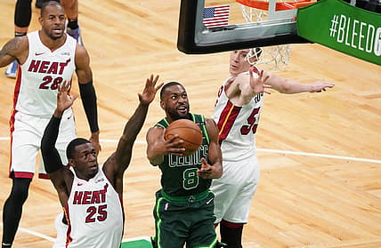 May 11, 2021; Boston, Massachusetts, USA; Boston Celtics guard Kemba Walker (8) makes the basket against Miami Heat guard Kendrick Nunn (25) and guard Duncan Robinson (55) in the third quarter at TD Garden. Mandatory Credit: David Butler II-USA TODAY Sports