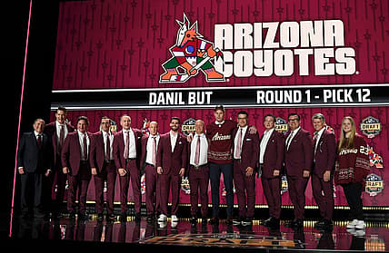 Jun 28, 2023; Nashville, Tennessee, USA; Arizona Coyotes draft pick Daniil But stands with Coyotes staff after being selected with the twelfth pick in round one of the 2023 NHL Draft at Bridgestone Arena. Mandatory Credit: Christopher Hanewinckel-USA TODAY Sports