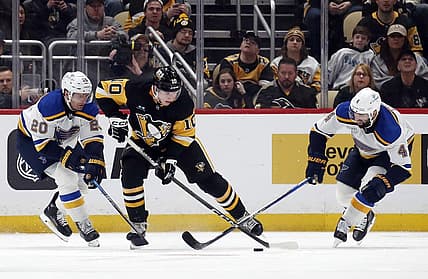 Dec 30, 2023; Pittsburgh, Pennsylvania, USA; Pittsburgh Penguins left wing Drew O'Connor (10) handles the puck against St. Louis Blues left wing Brandon Saad (20) and defenseman Nick Leddy (4) during the second period at PPG Paints Arena. Mandatory Credit: Charles LeClaire-USA TODAY Sports