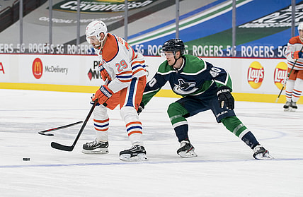 Feb 23, 2021; Vancouver, British Columbia, CAN; Edmonton Oilers forward Leon Draisaitl (29) moves the puck against Vancouver Canucks forward Elias Pettersson (40) in the third period at Rogers Arena. Oilers won 4-3. Mandatory Credit: Bob Frid-USA TODAY Sports