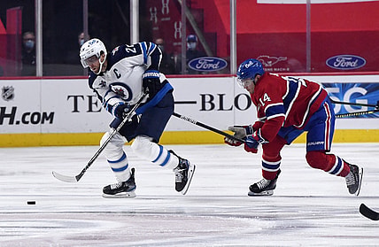 Apr 30, 2021; Montreal, Quebec, CAN; Winnipeg Jets forward Blake Wheeler (26) skates with the puck and Montreal Canadiens forward Nick Suzuki (14) defends during the first period at the Bell Centre. Mandatory Credit: Eric Bolte-USA TODAY Sports