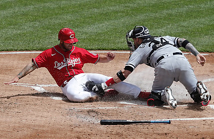May 5, 2021; Cincinnati, Ohio, USA; Cincinnati Reds center fielder Nick Senzel (left) is tagged out at home by Chicago White Sox catcher Yasmani Grandal (24) during the first inning at Great American Ball Park. Mandatory Credit: David Kohl-USA TODAY Sports