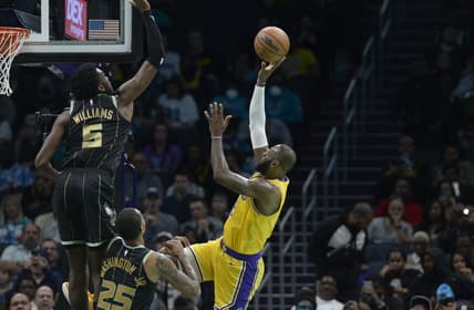 Jan 2, 2023; Charlotte, North Carolina, USA; Los Angeles Lakers forward LeBron James (6) shoots as he is defended by Charlotte Hornets center Mark Williams (5) and forward P.J. Washington (25) during first half at the Spectrum Center. Mandatory Credit: Sam Sharpe-USA TODAY Sports