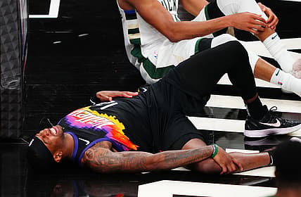 Jul 8, 2021; Phoenix, Arizona, USA; Phoenix Suns forward Torrey Craig (12) reacts after suffering an injury against the Milwaukee Bucks in game two of the 2021 NBA Finals at Phoenix Suns Arena. Mandatory Credit: Mark J. Rebilas-USA TODAY Sports