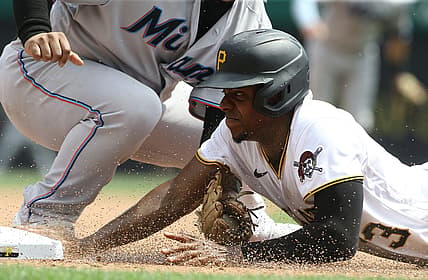 Jul 24, 2022; Pittsburgh, Pennsylvania, USA;  Pittsburgh Pirates third baseman Ke'Bryan Hayes (13) dives back into third base ahead of a tag attempt by Miami Marlins third baseman Willans Astudillo (left) during the sixth inning at PNC Park. Mandatory Credit: Charles LeClaire-USA TODAY Sports