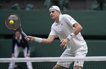 Jun 29, 2022; London, United Kingdom; John Isner (USA) returns a shot during his second round match against Andy Murray (GBR) on day three at All England Lawn Tennis and Croquet Club. Mandatory Credit: Susan Mullane-USA TODAY Sports