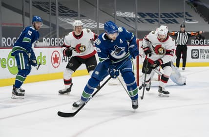 Jan 25, 2021; Vancouver, British Columbia, CAN; Ottawa Senators defenseman Christian Wolanin (24) checks Vancouver Canucks forward Brandon Sutter (20) in the first period at Rogers Arena. Mandatory Credit: Bob Frid-USA TODAY Sports