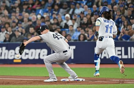 May 17, 2023; Toronto, Ontario, CAN;  New York Yankees pitcher Gerrit Cole (45) drops a throw to first base allowing Toronto Blue Jays shortstop Bo Bichette (11) to reach base safely in the first inning at Rogers Centre. Mandatory Credit: Dan Hamilton-USA TODAY Sports