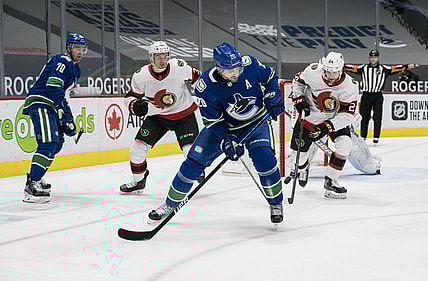 Jan 25, 2021; Vancouver, British Columbia, CAN; Ottawa Senators defenseman Christian Wolanin (24) checks Vancouver Canucks forward Brandon Sutter (20) in the first period at Rogers Arena. Mandatory Credit: Bob Frid-USA TODAY Sports