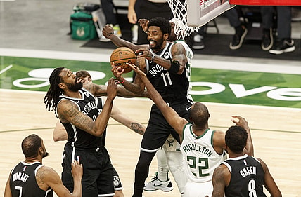 May 4, 2021; Milwaukee, Wisconsin, USA;  Brooklyn Nets center DeAndre Jordan (6), guard Kyrie Irving (11) and  Milwaukee Bucks forward Khris Middleton (22) reach for a rebound during the first quarter at Fiserv Forum. Mandatory Credit: Jeff Hanisch-USA TODAY Sports