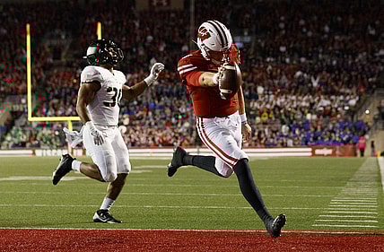 Oct 16, 2021; Madison, Wisconsin, USA;  Wisconsin Badgers quarterback Graham Mertz (5) rushes for a touchdown in front of Army Black Knights linebacker Daryan McDonald (30) during the second quarter at Camp Randall Stadium. Mandatory Credit: Jeff Hanisch-USA TODAY Sports