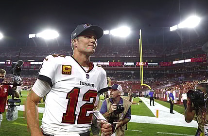 Jan 9, 2022; Tampa, Florida, USA;Tampa Bay Buccaneers quarterback Tom Brady (12) smiles as he runs off the field after they beat the against the Carolina Panthers at Raymond James Stadium. Mandatory Credit: Kim Klement-USA TODAY Sports