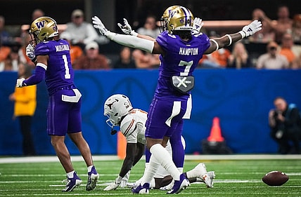 Texas Longhorns wide receiver Xavier Worthy (1) remains on the ground at the Washington Huskies defense, including cornerback Dominique Hampton (7) celebrate stopping a play in the second quarter of the Sugar Bowl College Football Playoff semi-finals at the Ceasars Superdome in New Orleans, Louisiana, Jan. 1, 2024. The Texas Longhorns take on the Washington Huskies for a spot in the College Football Playoff Finals.