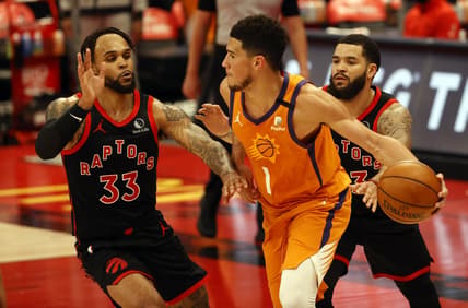 Mar 26, 2021; Tampa, Florida, USA;  Phoenix Suns guard Devin Booker (1) handles the ball as Toronto Raptors guard Fred VanVleet (23) and guard Gary Trent Jr (33) defend during the second half at Amalie Arena. Mandatry Credit: Kim Klement-USA TODAY Sports