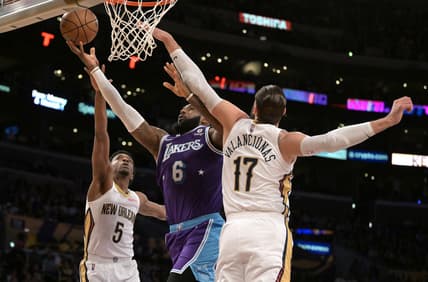 Apr 1, 2022; Los Angeles, California, USA;  Los Angeles Lakers forward LeBron James (6) is defended by New Orleans Pelicans forward Herbert Jones (5) and center Jonas Valanciunas (17) as he goes up for a basket in the first quarter of the game at Crypto.com Arena. Mandatory Credit: Jayne Kamin-Oncea-USA TODAY Sports