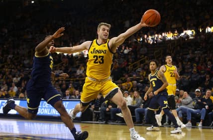 Iowa   s Ben Krikke (23) reaches for a ball, attempting to keep it inbounds Sunday, Dec. 10, 2023 at Carver-Hawkeye Arena in Iowa City, Iowa.