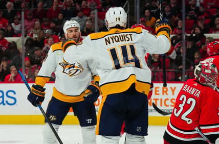 Dec 15, 2023; Raleigh, North Carolina, USA; Nashville Predators center Ryan O'Reilly (90) celebrates his gaol with center Gustav Nyquist (14) past Carolina Hurricanes goaltender Antti Raanta (32)  during the second period at PNC Arena. Mandatory Credit: James Guillory-USA TODAY Sports