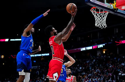Nov 19, 2021; Denver, Colorado, USA;  Chicago Bulls guard Coby White (0) shoots the ball past Denver Nuggets guard Monte Morris (11) in the second quarter at Ball Arena. Mandatory Credit: Ron Chenoy-USA TODAY Sports