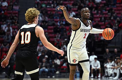 Dec 2, 2022; San Diego, California, USA; San Diego State Aztecs guard Adam Seiko (2) gestures while dribbling the ball as Occidental Tigers guard Aiden Williams (10) defends during the first half at Viejas Arena. Mandatory Credit: Orlando Ramirez-USA TODAY Sports