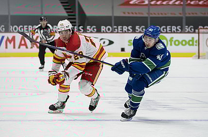 Feb 15, 2021; Vancouver, British Columbia, CAN; Vancouver Canucks defenseman Quinn Hughes (43) checks Calgary Flames forward Dillon Dube (29) in the first period at Rogers Arena. Mandatory Credit: Bob Frid-USA TODAY Sports