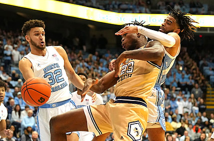 Dec 10, 2022; Chapel Hill, North Carolina, USA; North Carolina Tar Heels forward Pete Nance (32) and guard R.J. Davis (4) and Georgia Tech Yellow Jackets forward Jordan Meka (23) fight for the ball in the first half at Dean E. Smith Center. Mandatory Credit: Bob Donnan-USA TODAY Sports