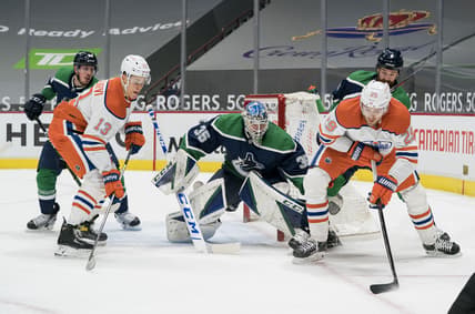 Feb 25, 2021; Vancouver, British Columbia, CAN; Vancouver Canucks goalie Thatcher Demko (35) makes a save on Edmonton Oilers forward Leon Draisaitl (29) as Edmonton Oilers forward Jesse Puljujarvi (13) and Vancouver Canucks defenseman Jordie Benn (8) look on in the first period at Rogers Arena. Mandatory Credit: Bob Frid-USA TODAY Sports