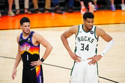 Jul 17, 2021; Phoenix, Arizona, USA; Milwaukee Bucks forward Giannis Antetokounmpo (34) against Phoenix Suns guard Devin Booker (1) during game five of the 2021 NBA Finals at Phoenix Suns Arena. Mandatory Credit: Mark J. Rebilas-USA TODAY Sports