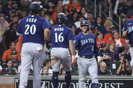 Jul 7, 2023; Houston, Texas, USA; Seattle Mariners designated hitter Mike Ford (20) and second baseman Kolten Wong (16) celebrate after scoring during the fourth inning against the Houston Astros at Minute Maid Park. Mandatory Credit: Troy Taormina-USA TODAY Sports