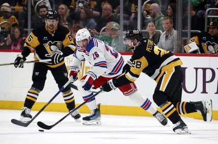 Mar 16, 2024; Pittsburgh, Pennsylvania, USA;  Pittsburgh Penguins defenseman Marcus Pettersson (28) moves the puck against New York Rangers left wing Jimmy Vesey (26) during the second period at PPG Paints Arena. Mandatory Credit: Charles LeClaire-USA TODAY Sports