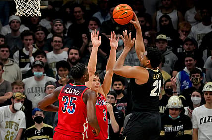Feb 26, 2022; Boulder, Colorado, USA; Colorado Buffaloes forward Evan Battey (21) shoots over Arizona Wildcats guard Pelle Larsson (3) and center Christian Koloko (35) in the first half at the CU Events Center. Mandatory Credit: Ron Chenoy-USA TODAY Sports