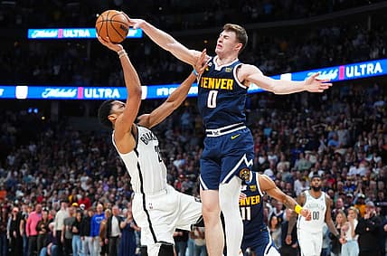 Mar 12, 2023; Denver, Colorado, USA; Denver Nuggets guard Christian Braun (0) blocks the shot of Brooklyn Nets guard Seth Curry (30) in the fourth quarter at Ball Arena. Mandatory Credit: Ron Chenoy-USA TODAY Sports