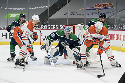 Feb 25, 2021; Vancouver, British Columbia, CAN; Vancouver Canucks goalie Thatcher Demko (35) makes a save on Edmonton Oilers forward Leon Draisaitl (29) as Edmonton Oilers forward Jesse Puljujarvi (13) and Vancouver Canucks defenseman Jordie Benn (8) look on in the first period at Rogers Arena. Mandatory Credit: Bob Frid-USA TODAY Sports