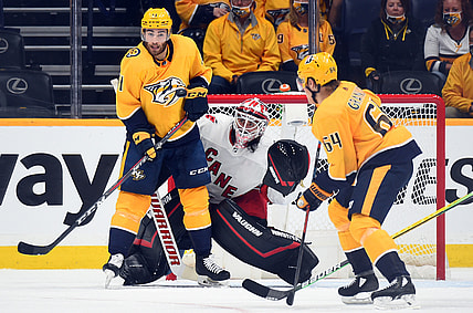 May 21, 2021; Nashville, Tennessee, USA; Nashville Predators center Luke Kunin (11) and Carolina Hurricanes goaltender Alex Nedeljkovic (39) watch a shot during the second period in game three of the first round of the 2021 Stanley Cup Playoffs at Bridgestone Arena. Mandatory Credit: Christopher Hanewinckel-USA TODAY Sports