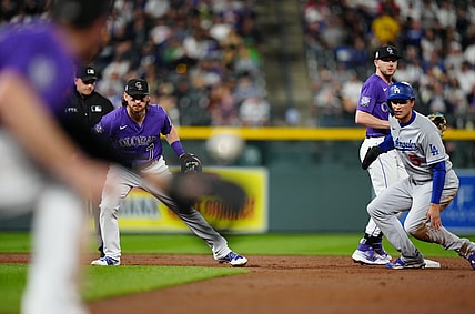 Sep 22, 2021; Denver, Colorado, USA; Los Angeles Dodgers shortstop Corey Seager (5) and Colorado Rockies shortstop Brendan Rodgers (7) and shortstop Trevor Story (27) look back to see the baseball in the fourth inning against the Colorado Rockies at Coors Field. Mandatory Credit: Ron Chenoy-USA TODAY Sports