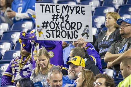 Dec 5, 2021; Detroit, Michigan, USA; A fans holds a sign for Tate Myre one of the Oxford High School shooting victims before the start of the NFL game between the Detroit Lions and the Minnesota Vikings at Ford Field. Mandatory Credit: David Reginek-USA TODAY Sports