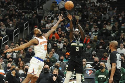 Jan 28, 2022; Milwaukee, Wisconsin, USA;  Milwaukee Bucks guard Jrue Holiday (21) shoots against New York Knicks guard Alec Burks (18) in the first half at Fiserv Forum. Mandatory Credit: Michael McLoone-USA TODAY Sports