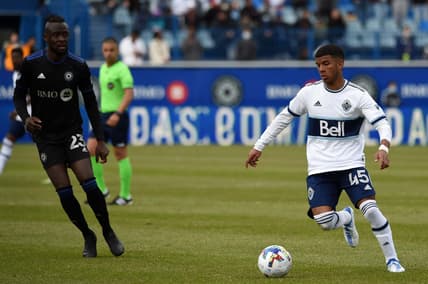 Apr 16, 2022; Montreal, Quebec, CAN;  Vancouver Whitecaps midfielder Pedro Vite (45) handles the ball as CF Montr  al forward Kei Kamara (23) defends during the second half at Stade Saputo. Mandatory Credit: David Kirouac-USA TODAY Sports