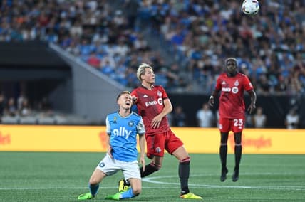 Aug 27, 2022; Charlotte, North Carolina, USA; Charlotte FC attacker Karol Swiderski (11) collides with Toronto FC defender Lukas MacNaughton (5) in the first half at Bank of America Stadium. Mandatory Credit: Griffin Zetterberg-USA TODAY Sports