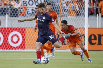 Jun 25, 2022; Houston, Texas, USA;  Chicago Fire midfielder Gaston Gimenez (30) kicks the ball as Houston Dynamo FC midfielder Memo Rodriguez (8) defends during the first half at PNC Stadium. Mandatory Credit: Troy Taormina-USA TODAY Sports