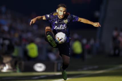 Oct 2, 2022; Kansas City, Kansas, USA; Seattle Sounders midfielder Cristian Roldan (7) leaps to receive a pass during the second half against the Sporting Kansas City at Children's Mercy Park. Mandatory Credit: Jay Biggerstaff-USA TODAY Sports