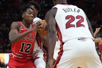 Oct 19, 2022; Miami, Florida, USA; Chicago Bulls guard Ayo Dosunmu (12) splits the defense of Miami Heat guard Kyle Lowry (7) and forward Jimmy Butler (22) in the first half at FTX Arena. Mandatory Credit: Jim Rassol-USA TODAY Sports