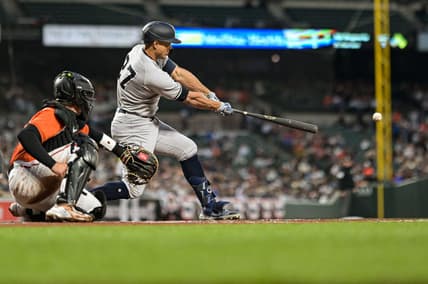 Apr 8, 2023; Baltimore, Maryland, USA;  New York Yankees right fielder Giancarlo Stanton (27) hits a third inning single against the Baltimore Orioles at Oriole Park at Camden Yards. Mandatory Credit: Tommy Gilligan-USA TODAY Sports