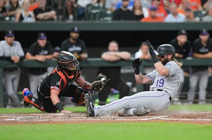 Aug 25, 2023; Baltimore, Maryland, USA; Colorado Rockies designated hitter Charlie Blackmon (19) slides past Baltimore Orioles catcher James McCann (27) to score during the second inning  at Oriole Park at Camden Yards. Mandatory Credit: Tommy Gilligan-USA TODAY Sports