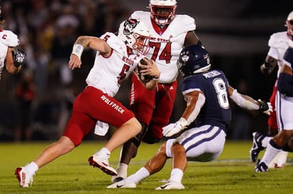 Aug 31, 2023; East Hartford, Connecticut, USA; North Carolina State Wolfpack quarterback Brennan Armstrong (5) runs the ball against UConn Huskies linebacker Jackson Mitchell (8) in the second quarter at Rentschler Field at Pratt & Whitney Stadium. Mandatory Credit: David Butler II-USA TODAY Sports