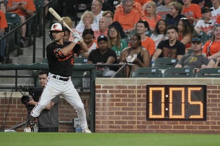 May 12, 2023; Baltimore, Maryland, USA;  Baltimore Orioles second baseman Adam Frazier (12) warms up next to the pitch clock during the third inning of the game against the Pittsburgh Pirates at Oriole Park at Camden Yards. Mandatory Credit: Tommy Gilligan-USA TODAY Sports
