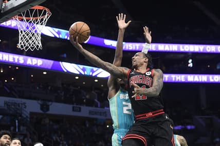 Jan 31, 2024; Charlotte, North Carolina, USA;  Chicago Bulls guard DeMar DeRozan (11) drives in for a lay-up past Charlotte Hornets forward guard Brandon Miller (24) during the second half at the Spectrum Center. Mandatory Credit: Sam Sharpe-USA TODAY Sports